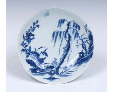 A Worcester Landslip pattern saucer, painted in blue with a small pavilion on a precipice, oversize flowering plants and will