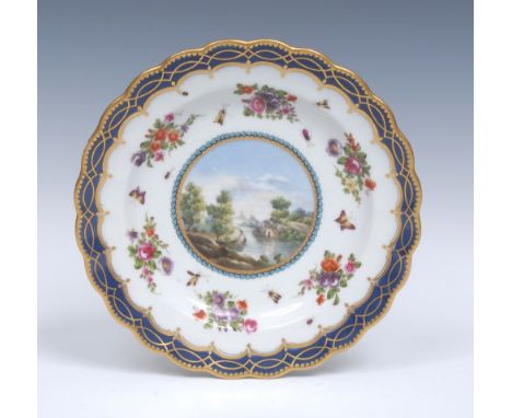 A Worcester fluted shaped circular dessert plate, decorated with a central cartouche painted  with  a boathouse and river sce