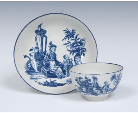 A Worcester Mother and Child tea bowl and saucer, printed in blue with oriental lady and child by jardiniere and flower vase,