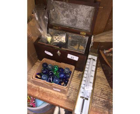 A thermometer, a box of marbles, a bag of Dominoes and an antique tea caddy.