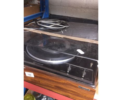 A vintage Garrard AP-75 turntable with cables and booklets 