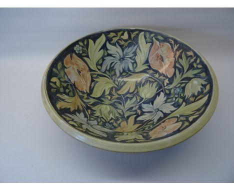 A Butley Pottery ceramic Bowl by Honor Hussey, decorated with pink and blue flowers on a blue ground.  13" (33cms) diameter.