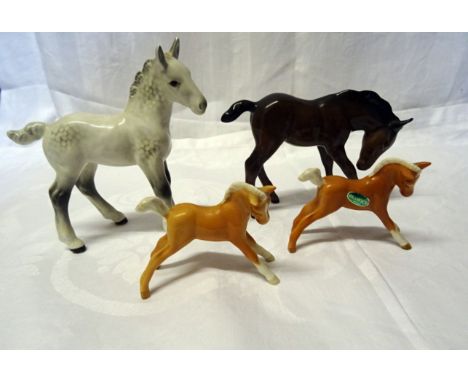 A Beswick Model of large shire foal in grey gloss, No. 951, a large brown foal, No. 947 and two small palomino foals No. 815.