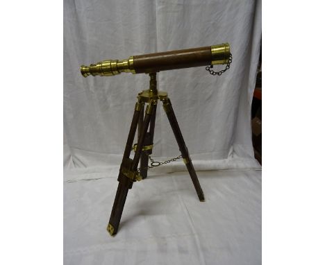 A brass and wooden covered Telescope on a tripod stand. 