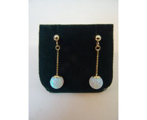 A pair of 9ct gold pendant Earrings, each set with a single opal. 