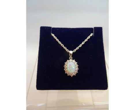 A silver oval Pendant set with an opal and cz's on a fine link neck chain. 