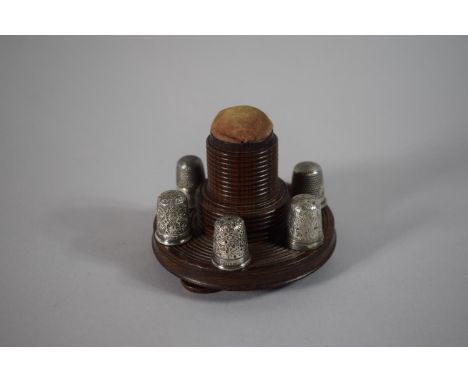 A Circular Treen Thimble Stand with Screw Off Pin Cushion and 6 Silver Thimbles, 8cms Diameter 