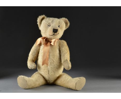 A 1930s British teddy bear, with light golden mohair, clear and black glass eyes, pronounced clipped muzzle, black stitched n