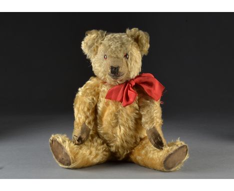 A Chiltern Hugmee teddy bear 1930s, with golden mohair, orange and black glass eyes, pronounced clipped muzzle, black stitche