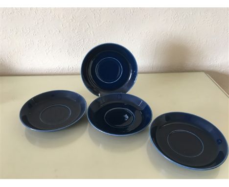 A set of four stunning deep-blue porcelain saucers from R?rstrand, Sweden. Each saucer features a sleek and minimalist design