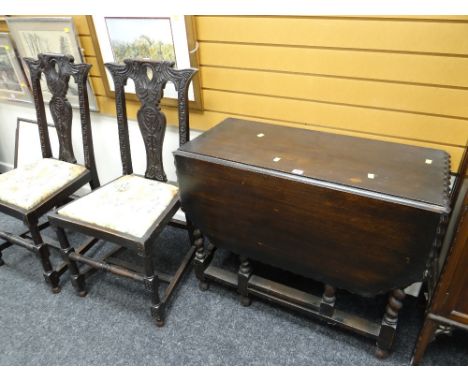 A stained vintage barley-twist gate leg table and two carved stained chairs with drop in seats