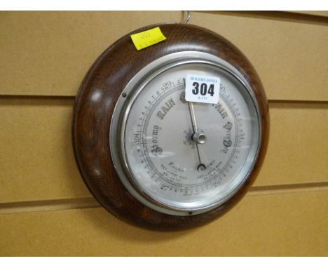 A circular oak framed wall barometer