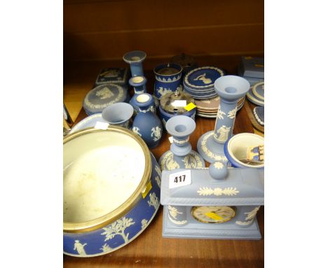 A quantity of blue Wedgwood Jasperware table items including mantel clock, salad bowl, candlestick holders etc