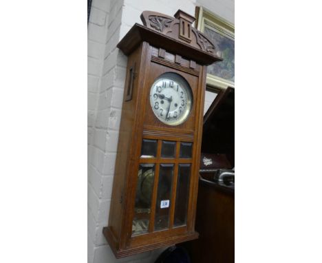 A 1930's striking wall clock in an oak and glazed case 