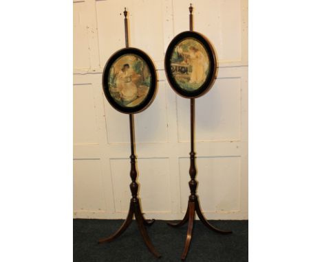 A pair of Victorian fire screens with oval silk embroidered panels of classical ladies, adjustable height on baluster stems a