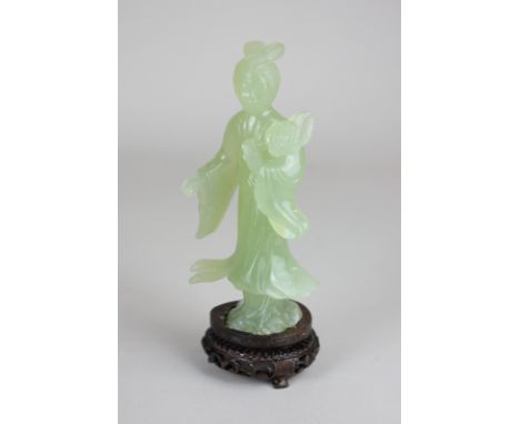 A 20th century carved celadon 'jade' figure of a woman with a blooming flower and flowing robes, 15cm, on hardwood stand 