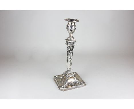A Victorian silver candlestick with embossed ribbon swag and ram's head decoration, on chamfered square base embossed with ur