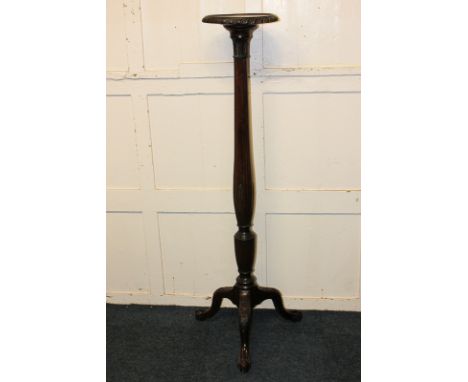 A mahogany torchiere on carved fluted support and tripod base with claw and ball feet, 141cm high