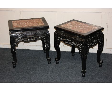 A pair of Chinese carved rosewood side tables with rectangular marble tops, pierced friezes, on shaped legs and scroll feet, 
