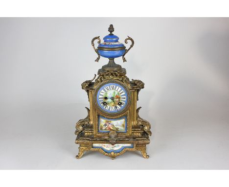 A 19th century French gilt mantel clock with Sevres style blue urn, face and panels depicting lovers fishing and a lakeside s