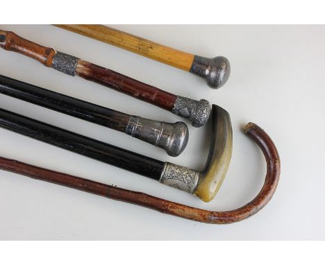 Four Edwardian and later silver mounted walking canes, one with a horn handle, together with a bentwood walking stick