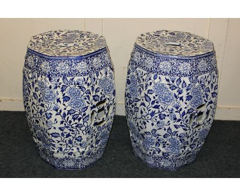 A pair of Chinese blue and white pottery octagonal stools with pierced detail and floral design, (one a/f), 47cm high