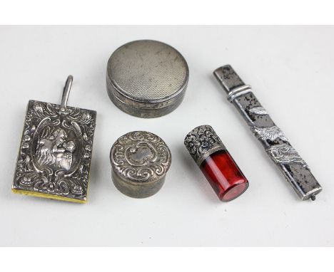 An Edwardian silver covered ivory notepad, a Chinese silver pencil holder, two silver pill pots and a red glass snuff bottle