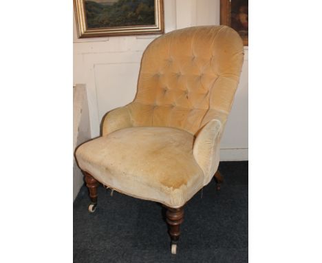 A Victorian button upholstered easy chair on turned legs and castors