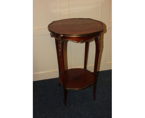 A French gilt metal mounted circular occasional table with parquetry top with central inlaid brass scroll motif, on shaped le