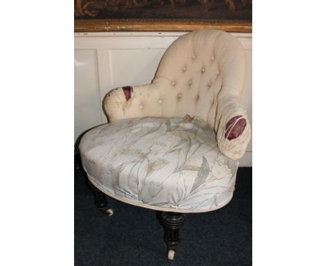 A Victorian button back upholstered easy chair on turned legs and castors