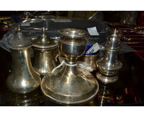 A silver boudoir candlestick;  a silver pepper pot;  another;  a silver mustard;  a silver salt;  all 20th century 