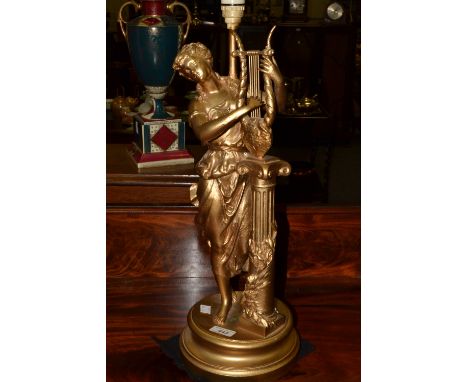 A gilt metal figural lamp, she stands playing a lyre, turned base, 58cm high