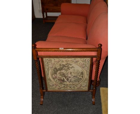 An early 20th century century oak fire screen, the glazed tapestry banner flanked by barley twist supports, c.1935