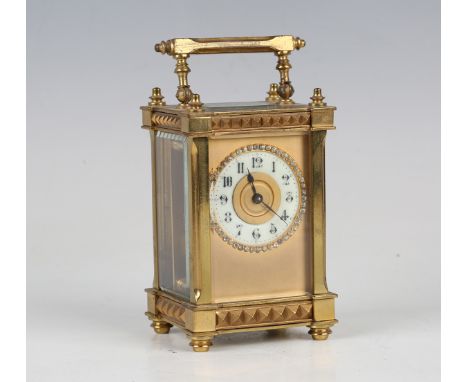 An early 20th century French gilt brass carriage timepiece with eight day movement, the cream chapter ring with black Arabic 
