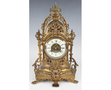 A late 19th century French gilt brass cased mantel clock with eight day movement striking on a gong, the circular enamelled d