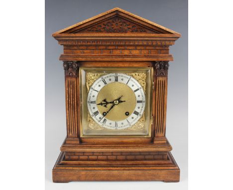 An early 20th century walnut cased mantel clock with eight day movement striking on a gong, the back plate stamped 'W &amp; H