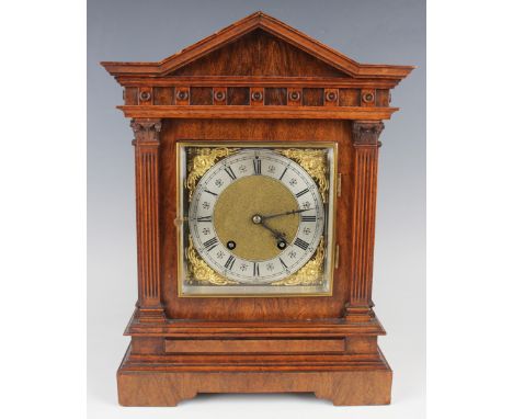 An early 20th century walnut mantel clock with eight day Lenzkirch movement striking on gongs, the square brass dial with mat