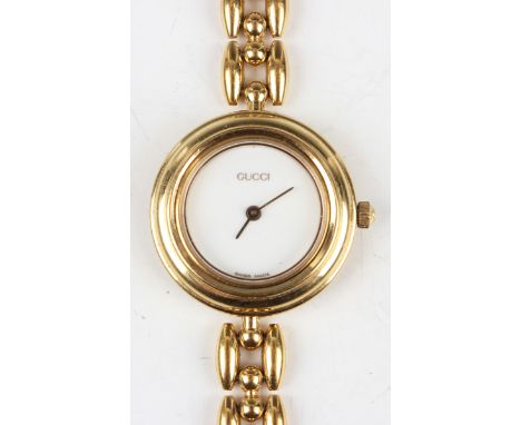 A Gucci gilt metal and interchangeable bezel lady's bracelet wristwatch with quartz movement and signed white dial, the circu