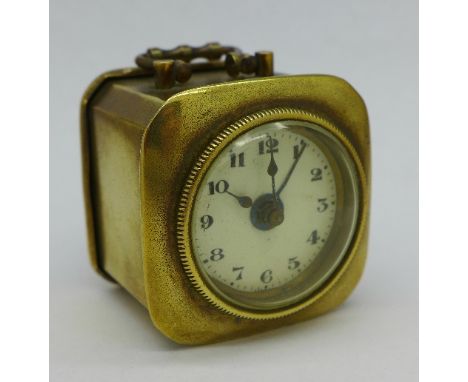 A small brass cased travel alarm clock