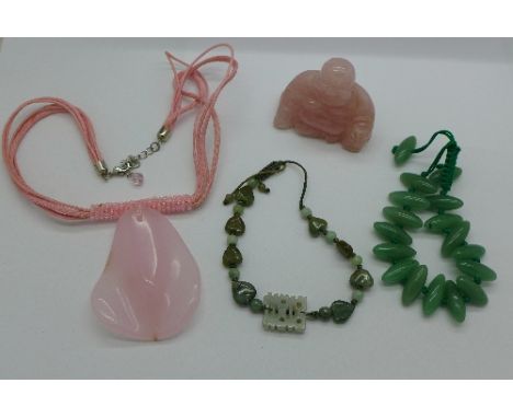 Two jade bracelets, a necklet and a carved Buddha