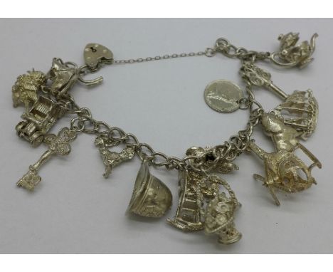 A silver bracelet with silver and white metal charms including a helicopter and a Policeman's helmet, 60g