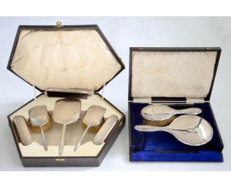 A GEORGE V SILVER HAND MIRROR AND MATCHING HAIR BRUSH, BIRMINGHAM 1922, CASED AND A SILVER SIX PIECE BRUSH SET BY WALKER AND 