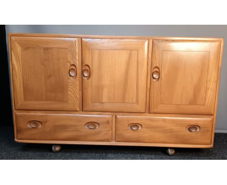 Vintage Ercol 'Windsor', small elm light wood sideboard on original castors. [77x130x44cm] 