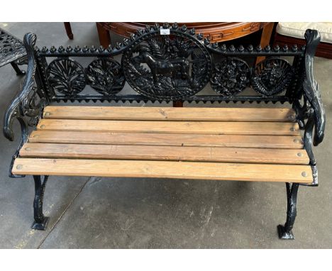 Black cast iron bench, the shaped back with dog and foliate design above a wooden slat seat and shaped arm rests [75x127x55cm