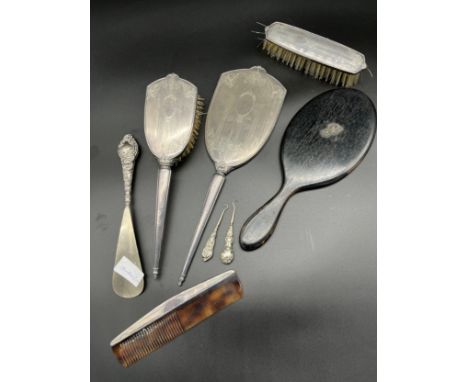 Lot of silver dressing table items to include brush, hand mirror, button hooks and ebony hand mirror. 