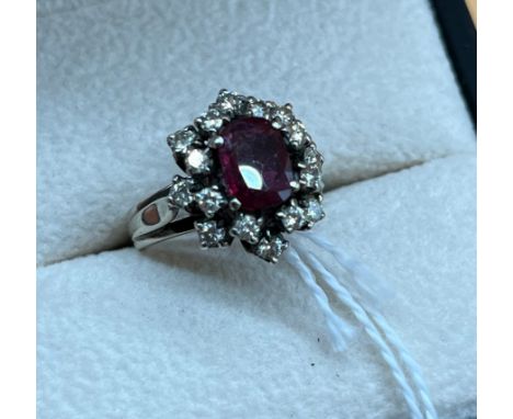 White gold/ platinum ladies diamond and ruby set ring. Fitted with 16 diamonds and one centre ruby. [Ruby- 0.8X0.6cm] [Ring s