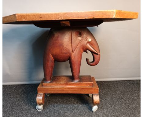 Ashanti elephant table, the octagonal top above a carved elephant, raised on a plinth base ending in roller wheels [67x81.5x6