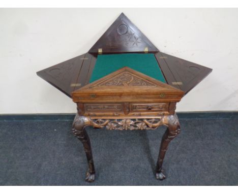 A 20th century heavily carved Chinese style envelope card table fitted with four drawers 