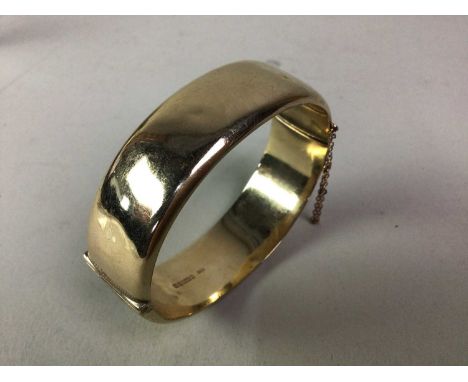 GOLD BANGLE, IN NINE CARAT GOLD oval form, with safety chain and marked for nine carat gold6.5cm wideQty: 22.25g 