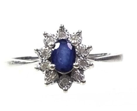 SAPPHIRE AND DIAMOND RING, set with an oval sapphire surrounded by illusion set diamonds, shank misshapen, in nine carat whit